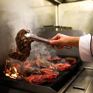 a chef grilling steak