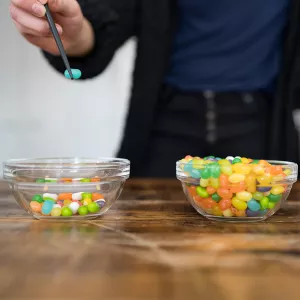 A Chopstick Challenge participant moves Jelly Beans from one bowl to another.