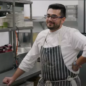 Chef Shant Halajian smiles inside of his kitchen