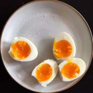 soft boiled eggs on a ceramic plate with maldon flaky salt