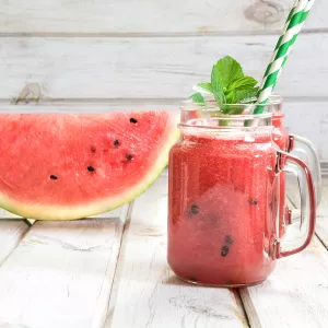 Jars of watermelon juice by a watermelon slice