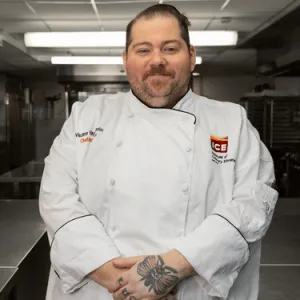 Chef-Instructor Vlad Vaynkhadler in chef whites in the kitchen. 