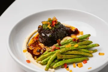 Plate with green beans, polenta, and steak.