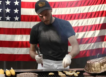 ICE alum James Durrazo on the grill with corn and meat in front of an American flag. 