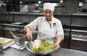 ICE student mixing a salad.