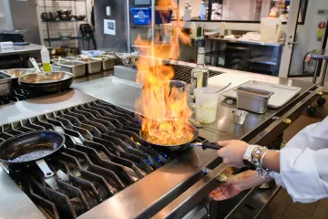 A chef cooks with a pan on fire.
