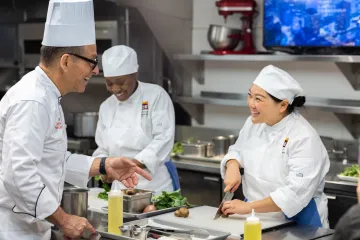 Happy ICE students practicing knife skills in the kitchen. 