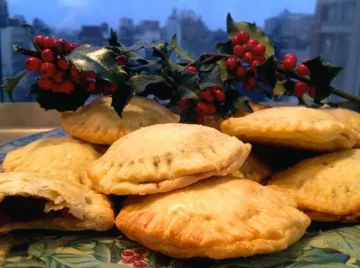 Pile of mince tartelettes in front of holly.