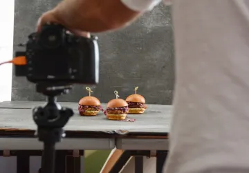 Image of sliders in front of a camera to represent food media. 