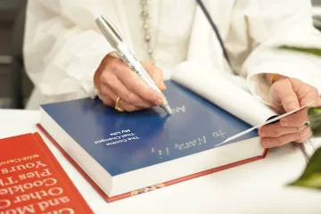 Cookbook author writes name at book signing at ICE LA campus