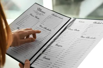 Person reading a menu. Credit: Pixelshot