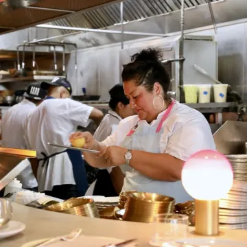 Chef Ayesha Nurdjaja working at her restaurant kitchen.