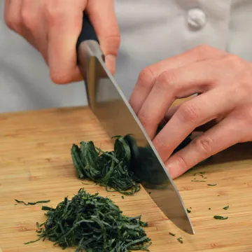 Hands chop kale