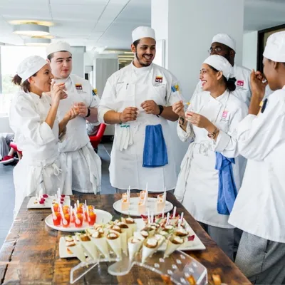 Culinary Class gathering around table of canapes.