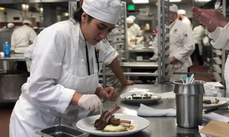 A Culinary Arts student plates a lamb dish