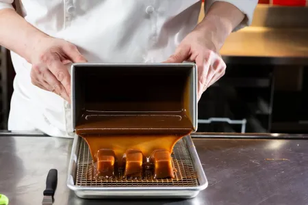 a Advanced Pastry & Baking Technique student pours caramel over candies