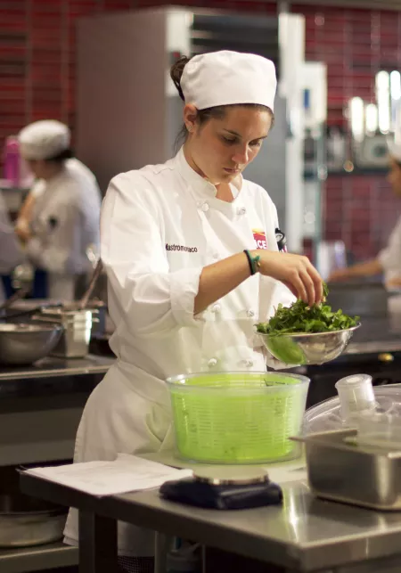 culinary student mixing greens
