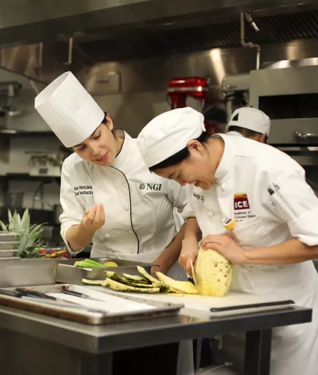 student cutting pineapple in New York plant-based culinary program
