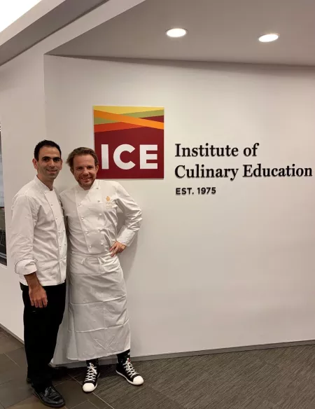 Chefs Nicolas Sale and Oliver Laine from the Ritz Paris pose in front of ICE logo