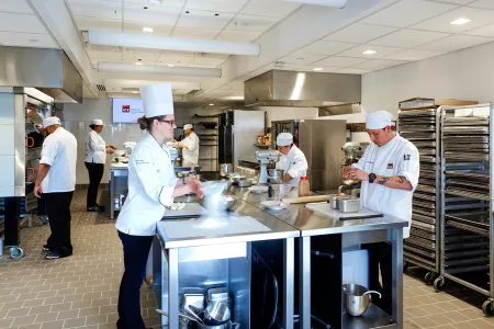 Pastry arts students and chef instructors in a pastry kitchen at the Institute of Culinary Education