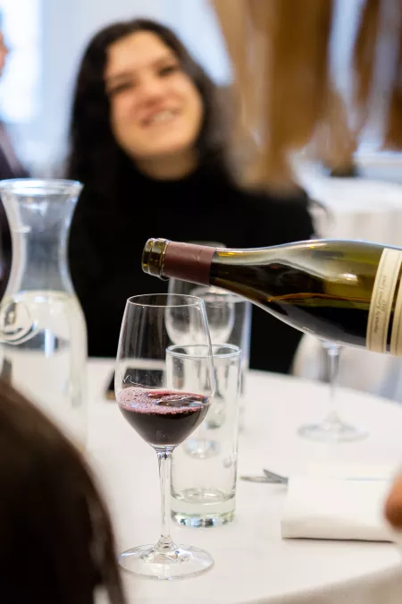 Red wine is poured for a student in the sommelier continuing education course