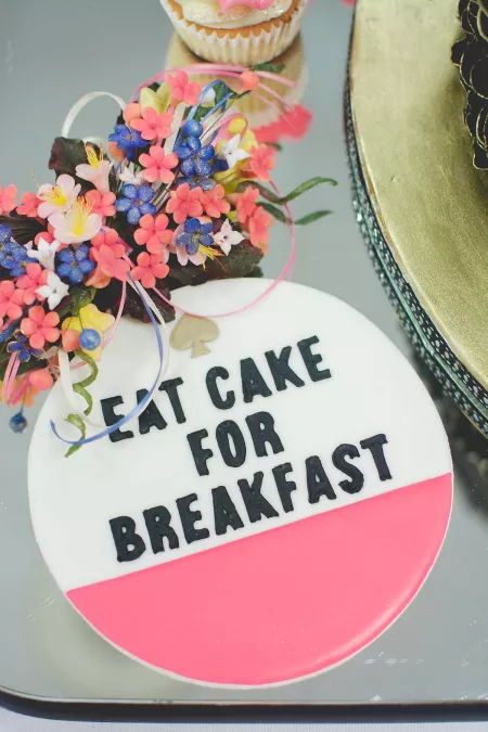 A cookie that is decorated to say Eat Cake for Breakfast from the ICE Professional Cake Decorating Program