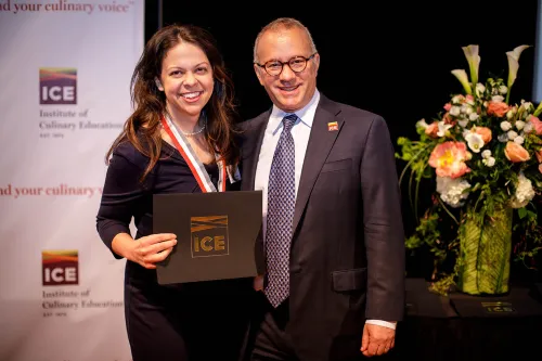 A student receives her diploma at the Institute of Culinary Education 2017 commencement ceremony