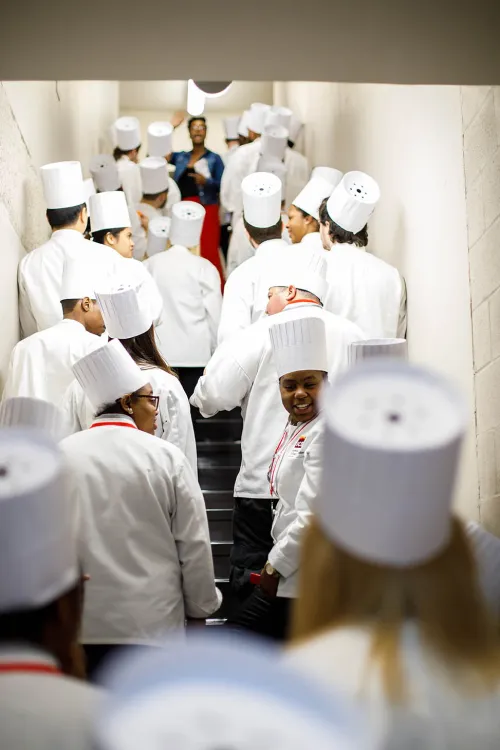 Students get ready to celebrate their graduation ceremony from the Institute of Culinary Education