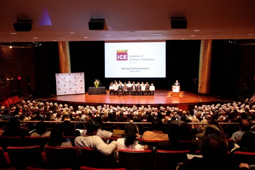 Students listen to speakers at their graduation ceremony from the Institute of Culinary Education