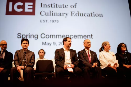 Guest speaker Chef Michael Anthony of Gramercy Tavern waits to address the students at their graduation ceremony from the Institute of Culinary Education