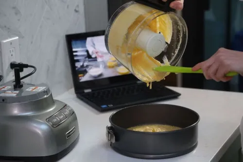 pouring batter while watching online cooking lesson with chef-instructor