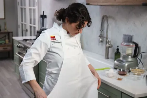 culinary student puts on her apron