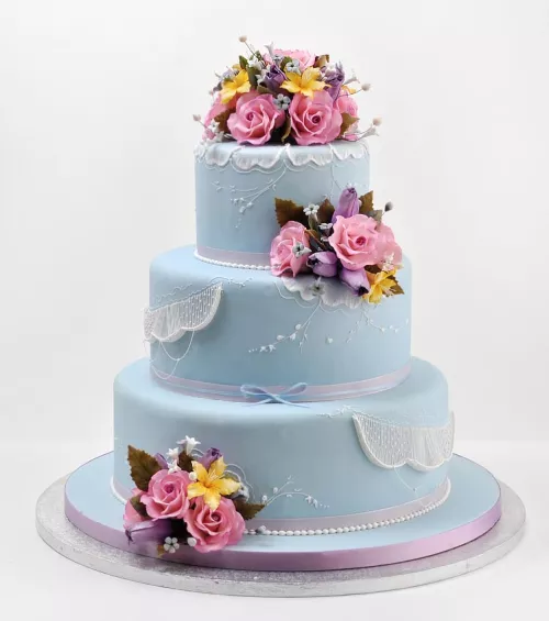 Blue cake with pink gumpaste flowers from the ICE Professional Cake Decorating continuing education program