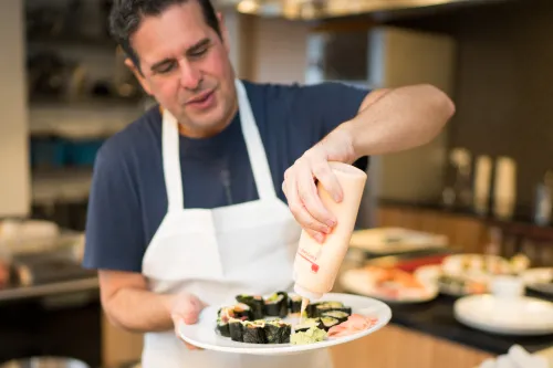 A guest adds sauce to his sushi.
