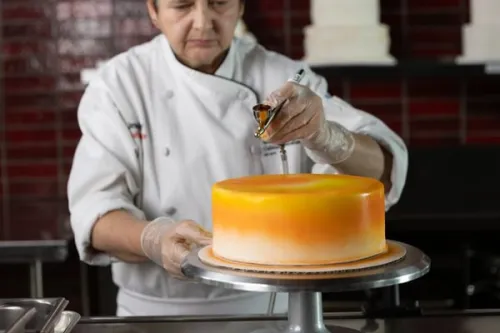 ICE Chef-Instructor demonstrates air brushing in a test kitchen. 