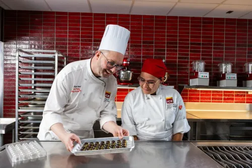 an Advanced Pastry & Baking Technique instructor and student work on preparing Bonbons