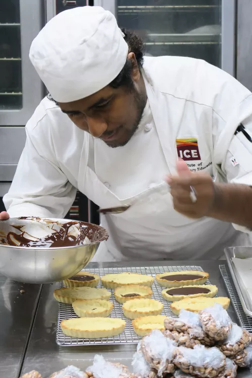 ICE LA pastry student filling a pastry shell in ICE's pastry arts program Los Angeles