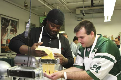 A Jets player and fan cook together.