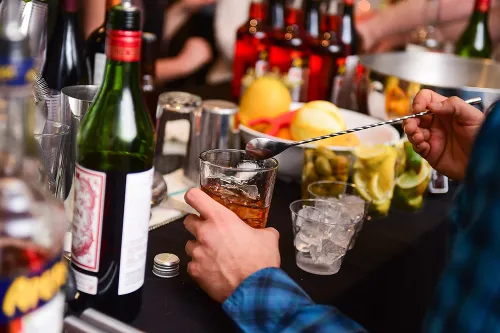 A bartender mixes a drink at a beverage station