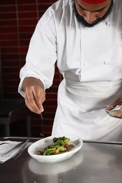a Culinary Nutrition student garnishes his plate