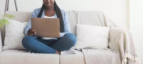 a student studies online learning on a couch