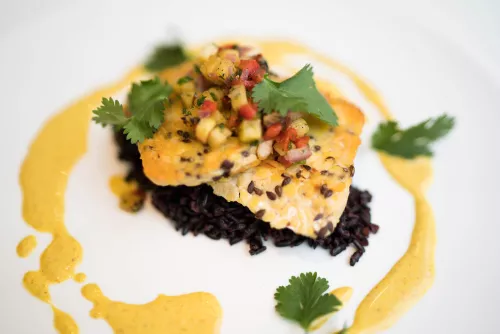 Seared tempeh is served with black rice and a pineapple and red onion relish.