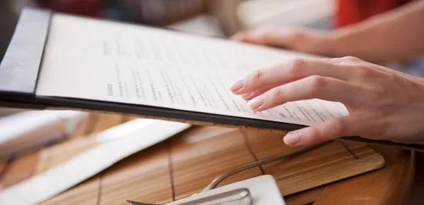 Hand with a restaurant menu. 