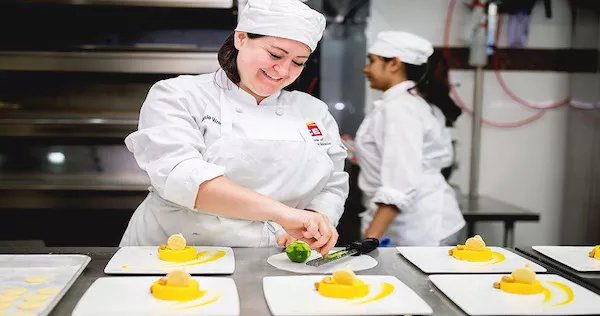 A Pastry & Baking Arts student plates yellow desserts