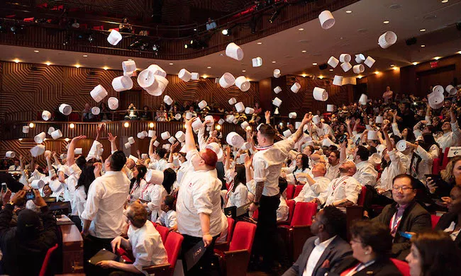 Culinary Arts & Food Operations students toss their toques into the air at ICE graduation