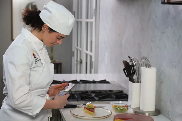 ICE online student taking a photo of her food with her phone. 