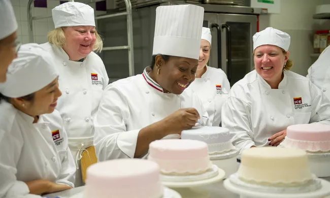 ICE Chef Instructor Toba Garrett demonstrates cake decorating techniques to a group of students