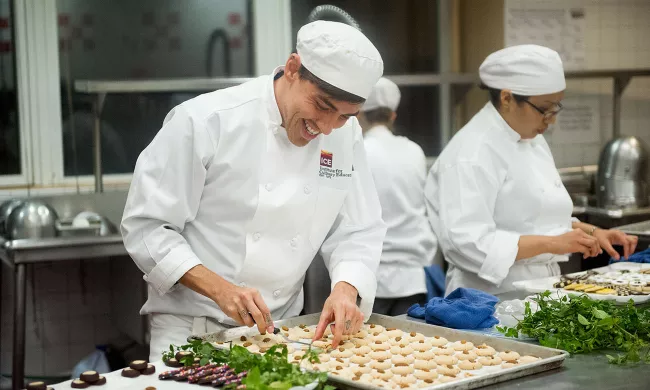 An ICE pastry arts student checks cookies on a sheet tray