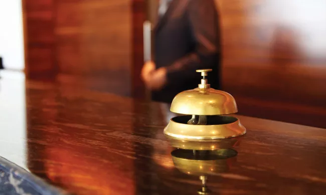A hotel bell on the front desk of a hotel lobby