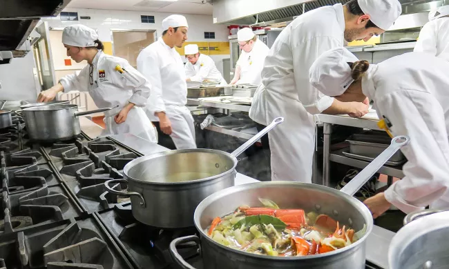 Students prepare dishes in the culinary arts campus programs at the Institute of Culinary Education.